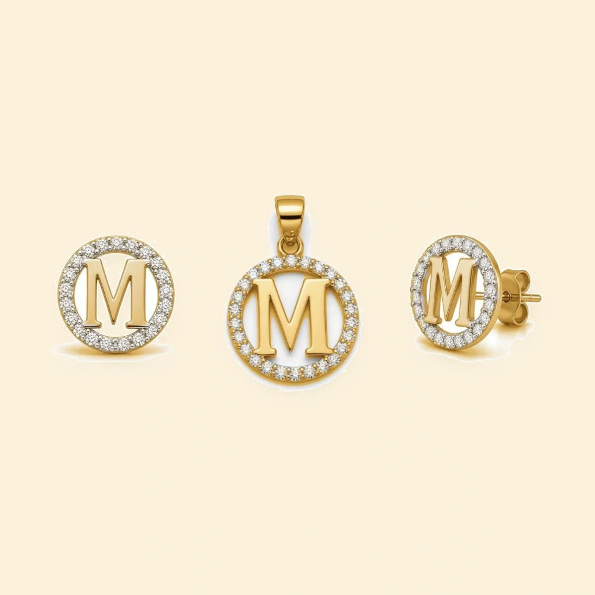 Gold plated sterling silver CZ initial M pendant set on ivory background