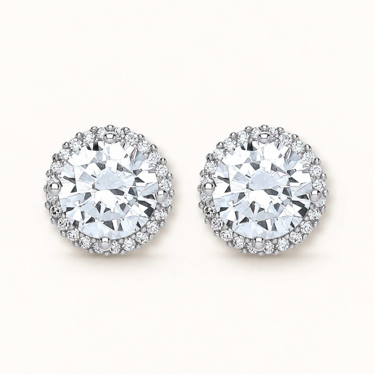Silver CZ halo earrings on ivory background