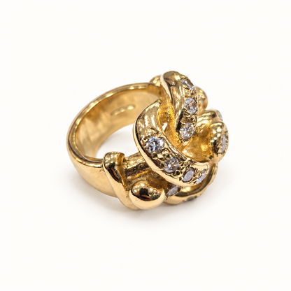 9ct gold lovers knot CZ ring, side view on ivory