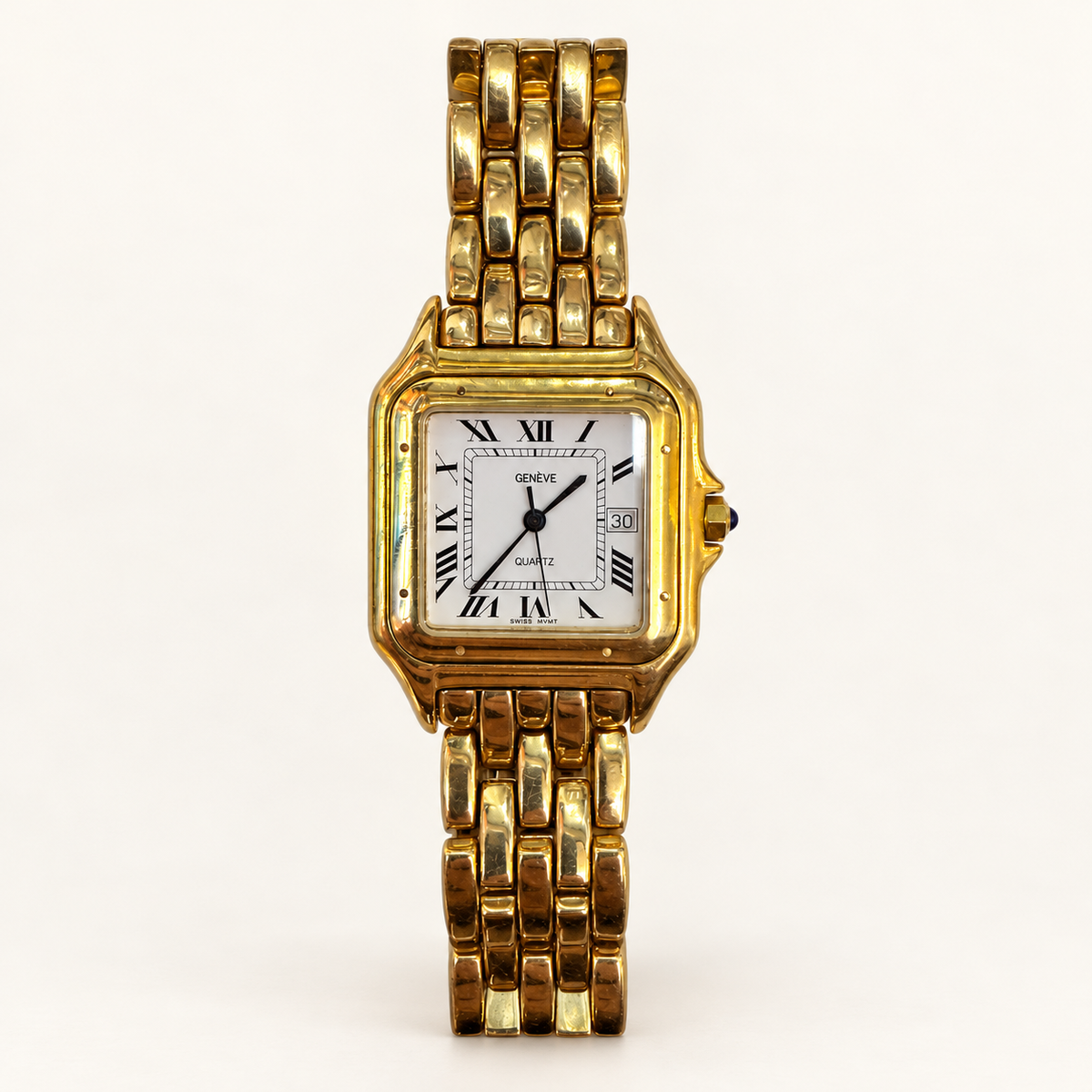 Genève rectangular gold quartz watch with white Roman-numeral dial and gold link bracelet on an ivory background
