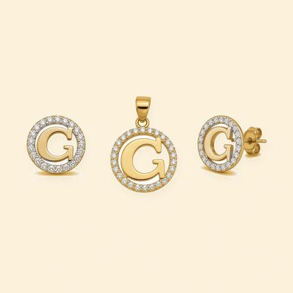 Gold plated sterling silver CZ initial G pendant set on ivory background