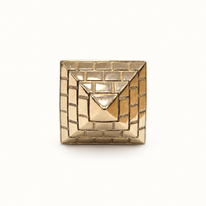 Men's gold geometric Pyramid signet ring, front view on ivory
