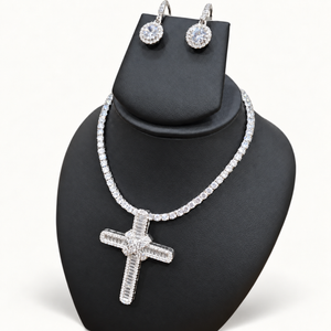 Silver CZ cross set on black bust against neutral ivory studio background